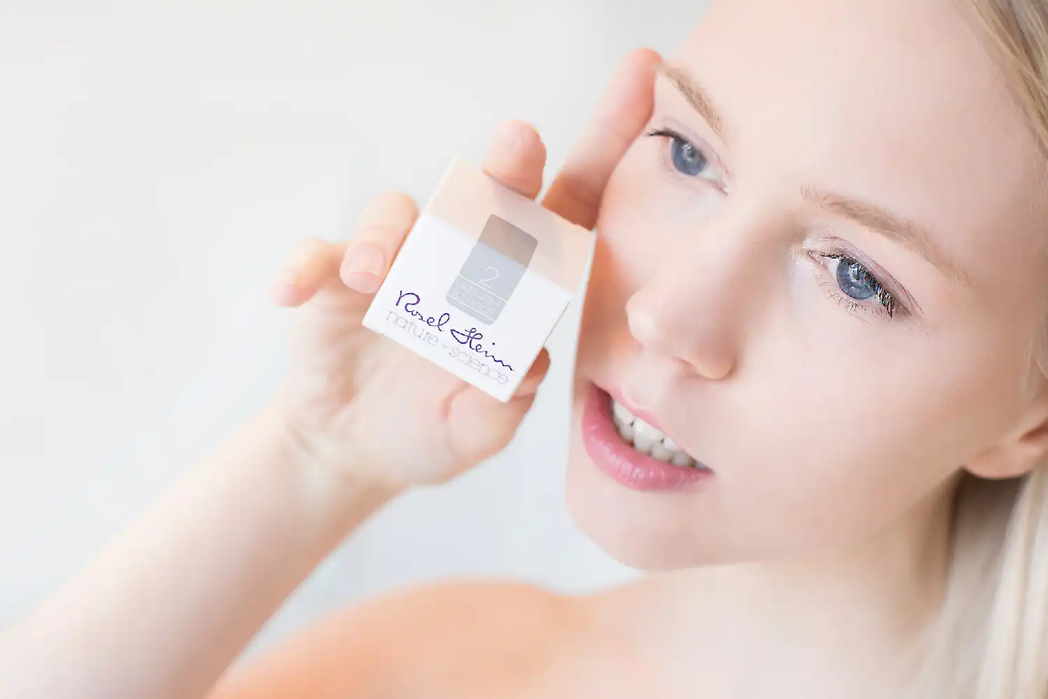 Periorale Dermatitis 2 Eine Frau hält eine Schachtel Kosmetik hoch.