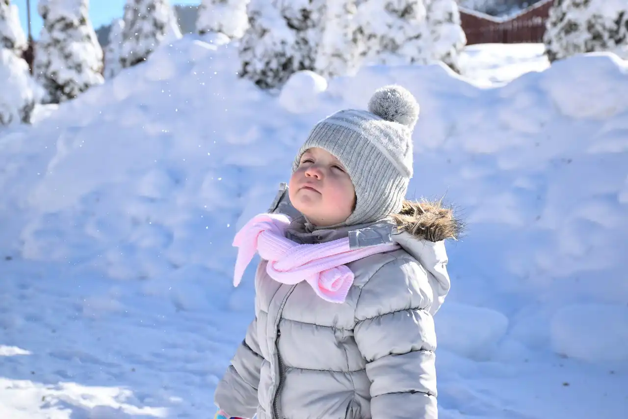 Ein kleines Mädchen steht im Winter.