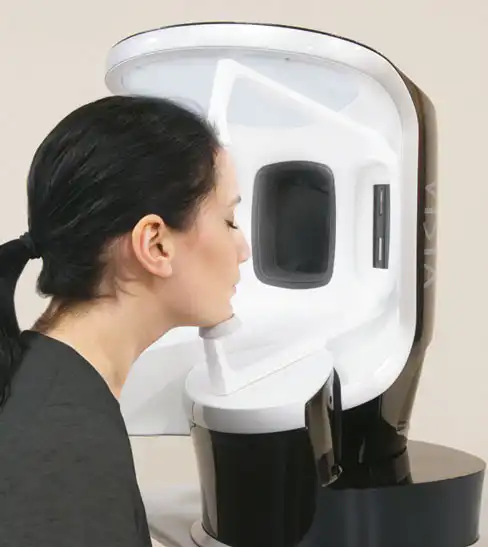 Eine Frau analysiert ihre Haut mit einem VISIA-Gerät.